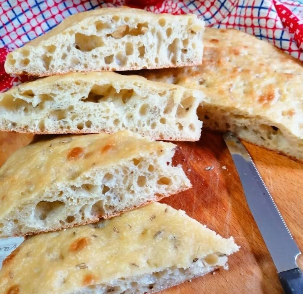 schiacciata-olive-oil-wine-class Freshly baked schiacciata from a cooking class, golden brown with a crisp crust.