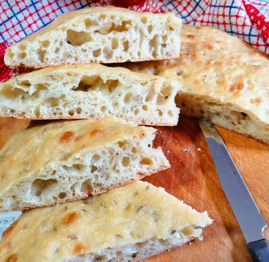 Guests preparing schiacciata dough during a Tuscan baking class paired with wine tasting.