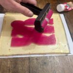 Rolling magenta acrylic color onto a gel plate at a gel plate printing Florence workshop for kids at Fatacadabra