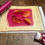 Autumn leaves arranged on a pink acrylic gel plate at a kids art Florence, Fatacadabra