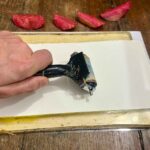 Rolling paper onto the gel plate to transfer the print at a family activities Florence workshop