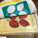 Peeling back paper to reveal a teal leaf monoprint at a kids art workshop Tuscany, Fatacadabra