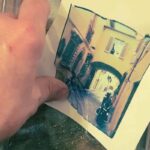 Hands transferring a Polaroid emulsion image of a Florence street scene to watercolor paper