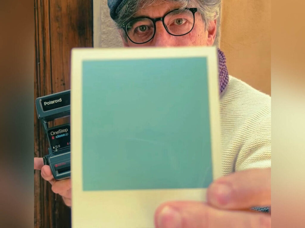 Leo holding a freshly ejected Polaroid film during the Polaroid workshop Florence at Fatacadabra