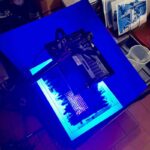 UV exposure unit glowing blue at Fatacadabra cyanotype printing Florence workshop, with finished prints visible