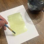 Coating paper with cyanotype emulsion during a hands-on workshop Florence at Fatacadabra