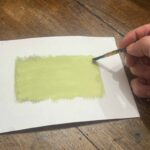 Hand brushing cyanotype emulsion across paper at a creative workshop Florence, Fatacadabra