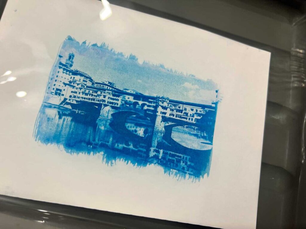 Cyanotype print of Ponte Vecchio developing in water during a photography workshop Florence at Fatacadabra