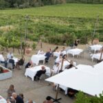Outdoor Tuscan lunch setup on a winery terrace overlooking Chianti vineyards