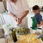 Chef and child finishing a fresh pasta dish during a family-friendly cooking class in Florence.