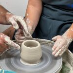 Guest shaping a ceramic vessel during a Tuscan ceramics masterclass near Florence