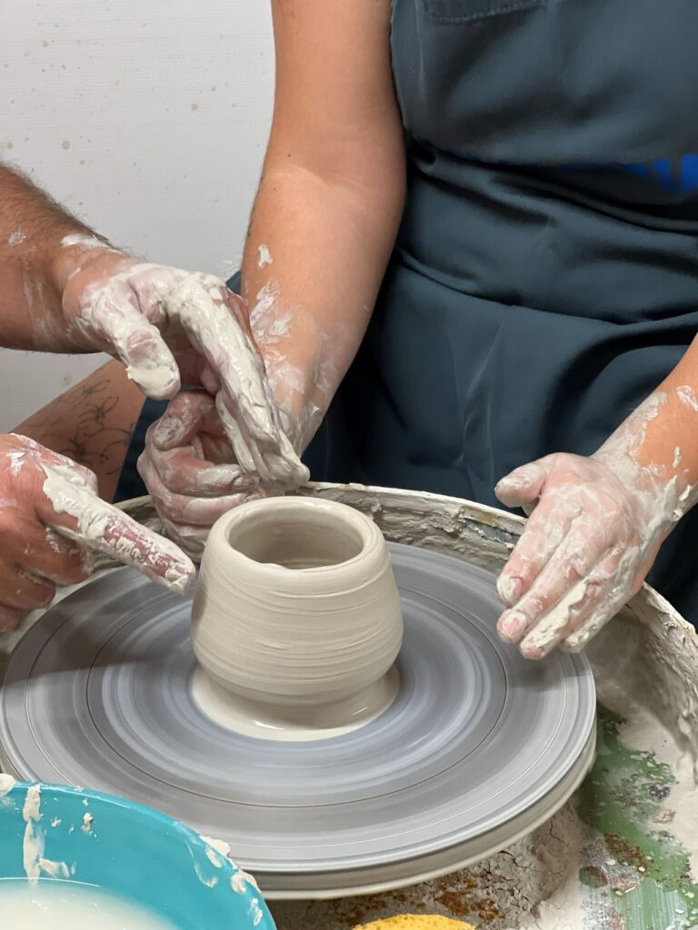 Guest shaping a ceramic vessel during a Tuscan ceramics masterclass near Florence