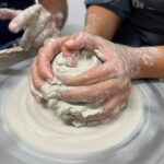 Guest shaping a ceramic vessel on the wheel during the hands-on workshop near Florence