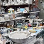 Pottery tools, brushes, and wet clay on a workshop table during a Tuscan ceramic masterclass.