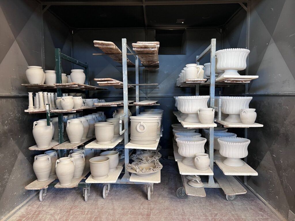 Unfired pottery drying on racks after the Tuscany wheel workshop session