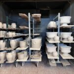 Unfired pottery drying on racks after the Tuscany wheel workshop session