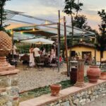 Guests dining outdoors at Bio e Brado organic farm in Impruneta at sunset after a horseback ride — horseback riding in Italy