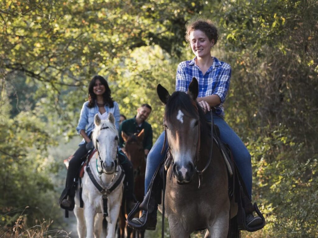 Margherita, local horse riding guide, with horses at an organic farm in Impruneta near Florence, Tuscany.