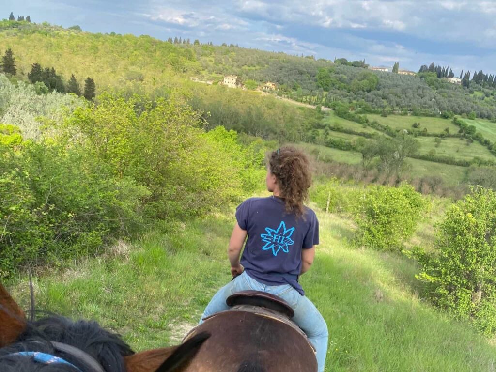 Point of view from horseback on a trail through the Tuscan countryside with cypress trees and green hills near Florence — horseback riding near Florence